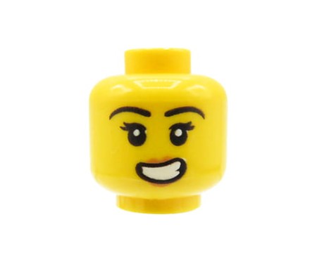 Głowa figurki LEGO w kolorze żółtym, damska, szeroki śmiech, czarne brwi, rzęsy.